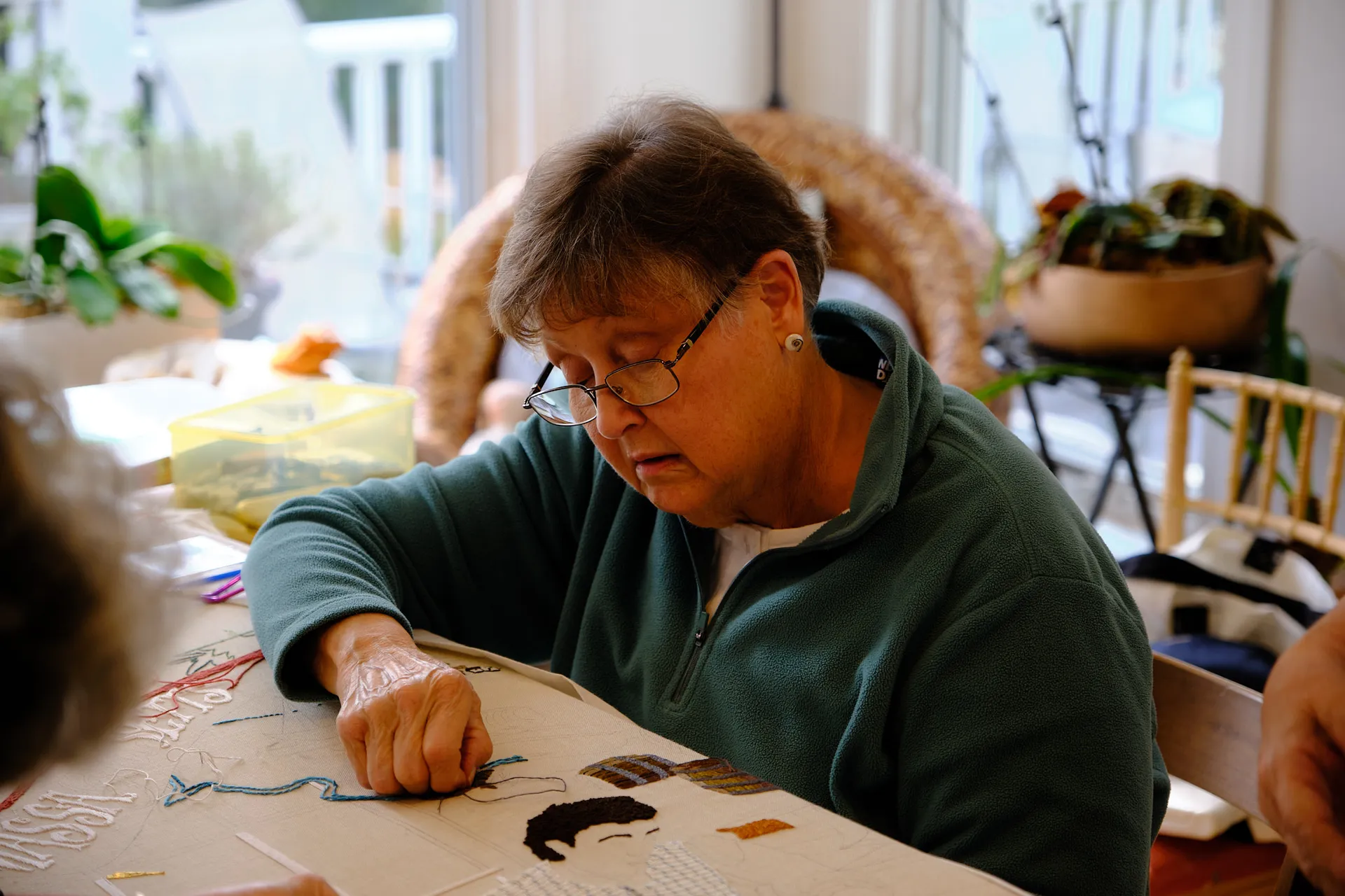 A stitcher embroidering a portrait on the Massachusetts panel
