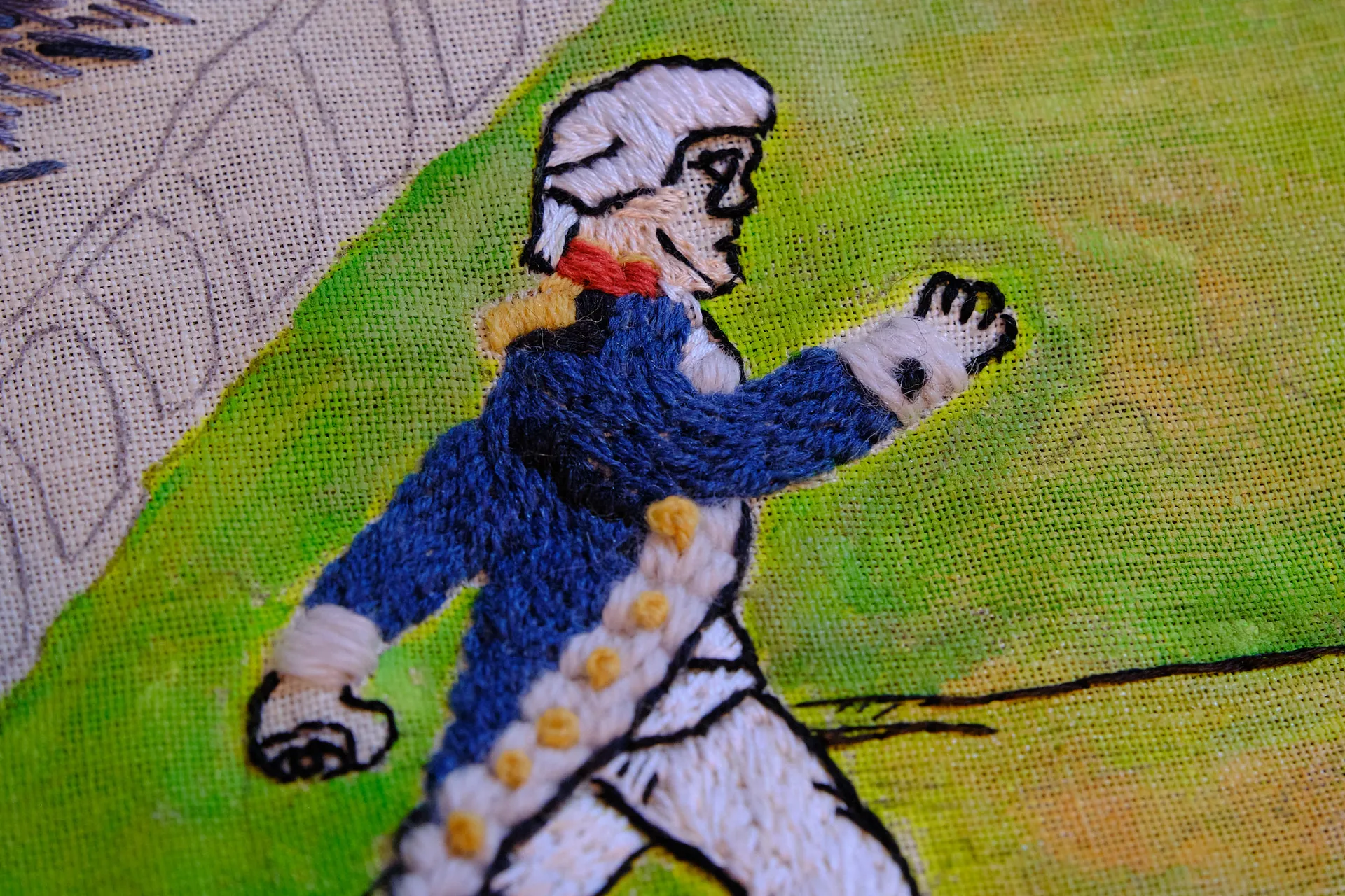 An embroidered colonial officer in a blue coat, a detail from the Rhode Island panel
