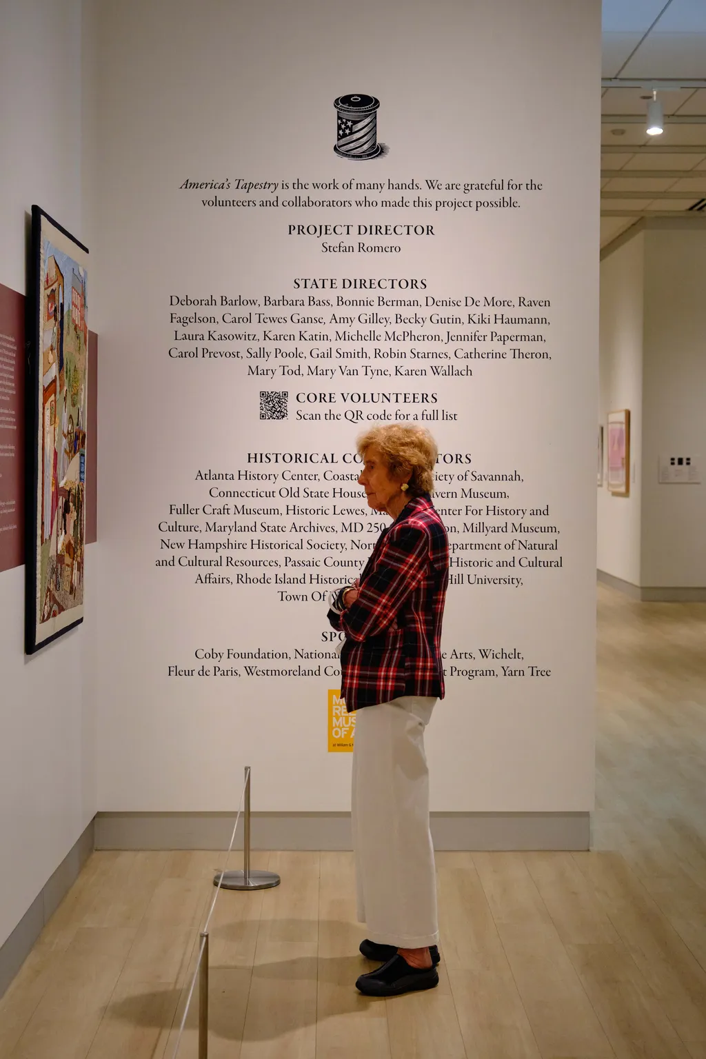 A visitor reads about the New Jersey panel of America's Tapestry