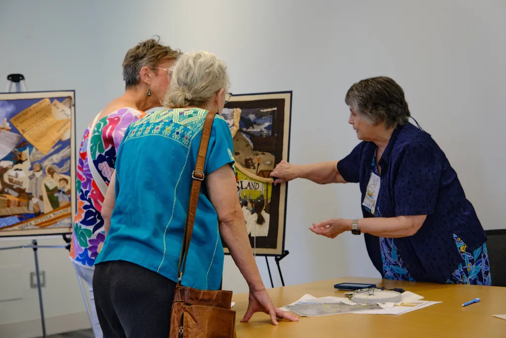 Rhode Island volunteer Hope Brans shares information with visitors during the Stitcher's Showcase