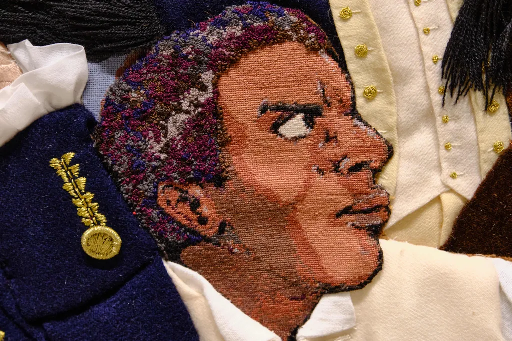 Visitors examine the face of Thomas Carney, a Maryland soldier stitched in petit-point