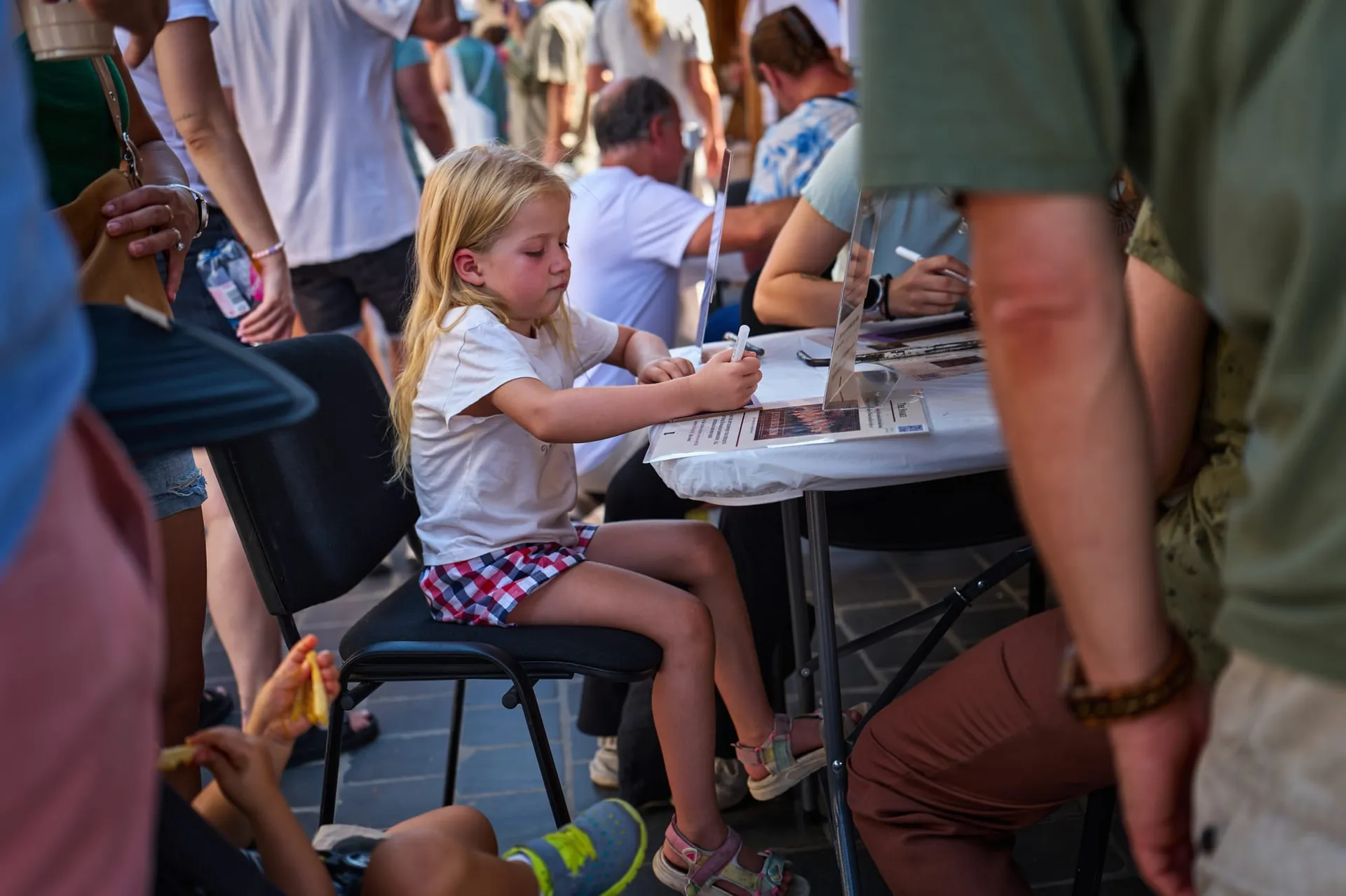 A child writes on a fabric rectangle for the panel