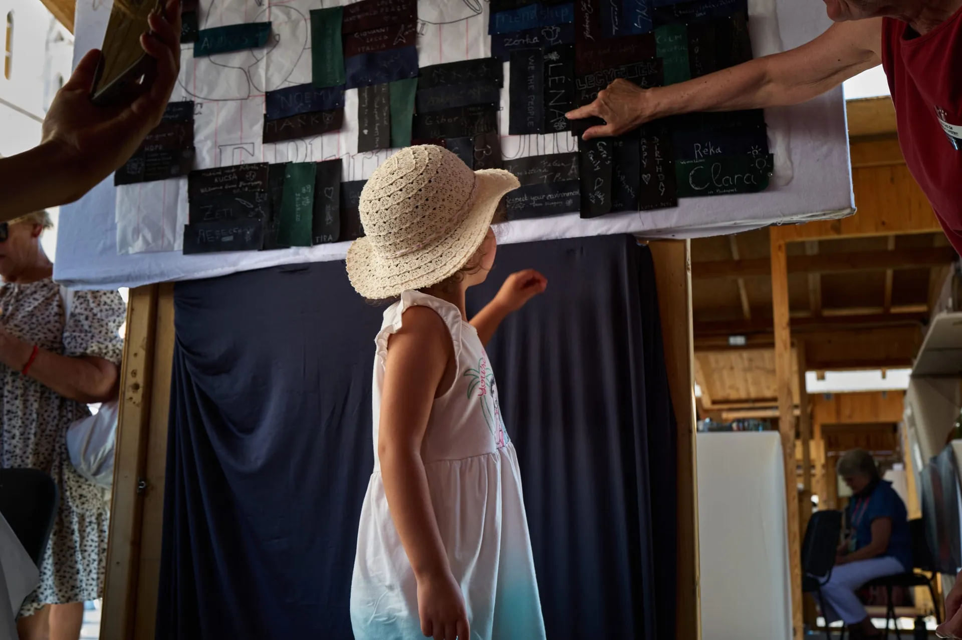 A visitor bends to study the panel in progress