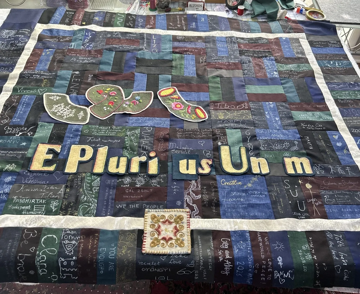 The rattlesnake pieces and lettering laid out on the patchwork