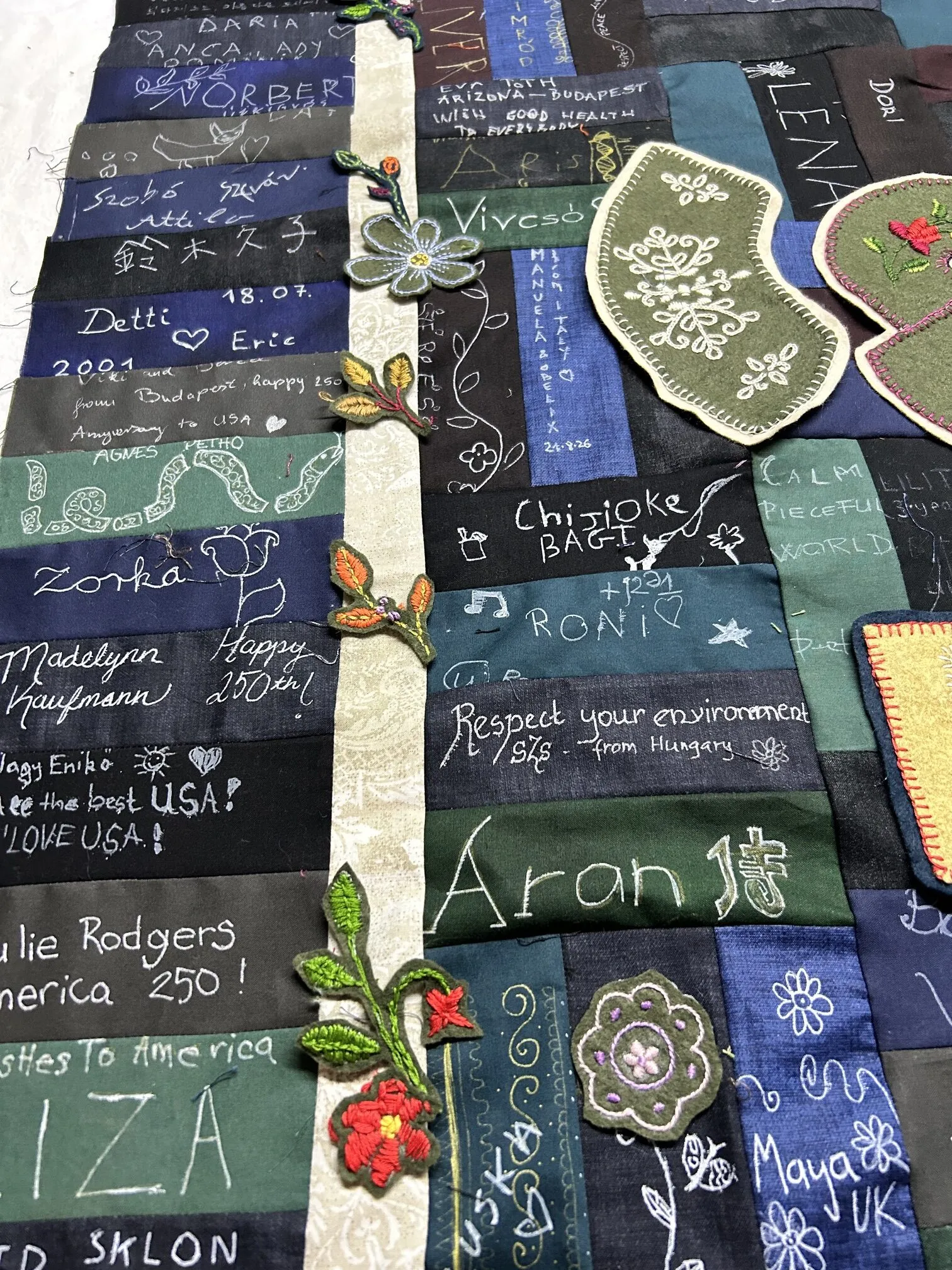 Detail: floral motifs stitched along the border among the visitors' inscriptions